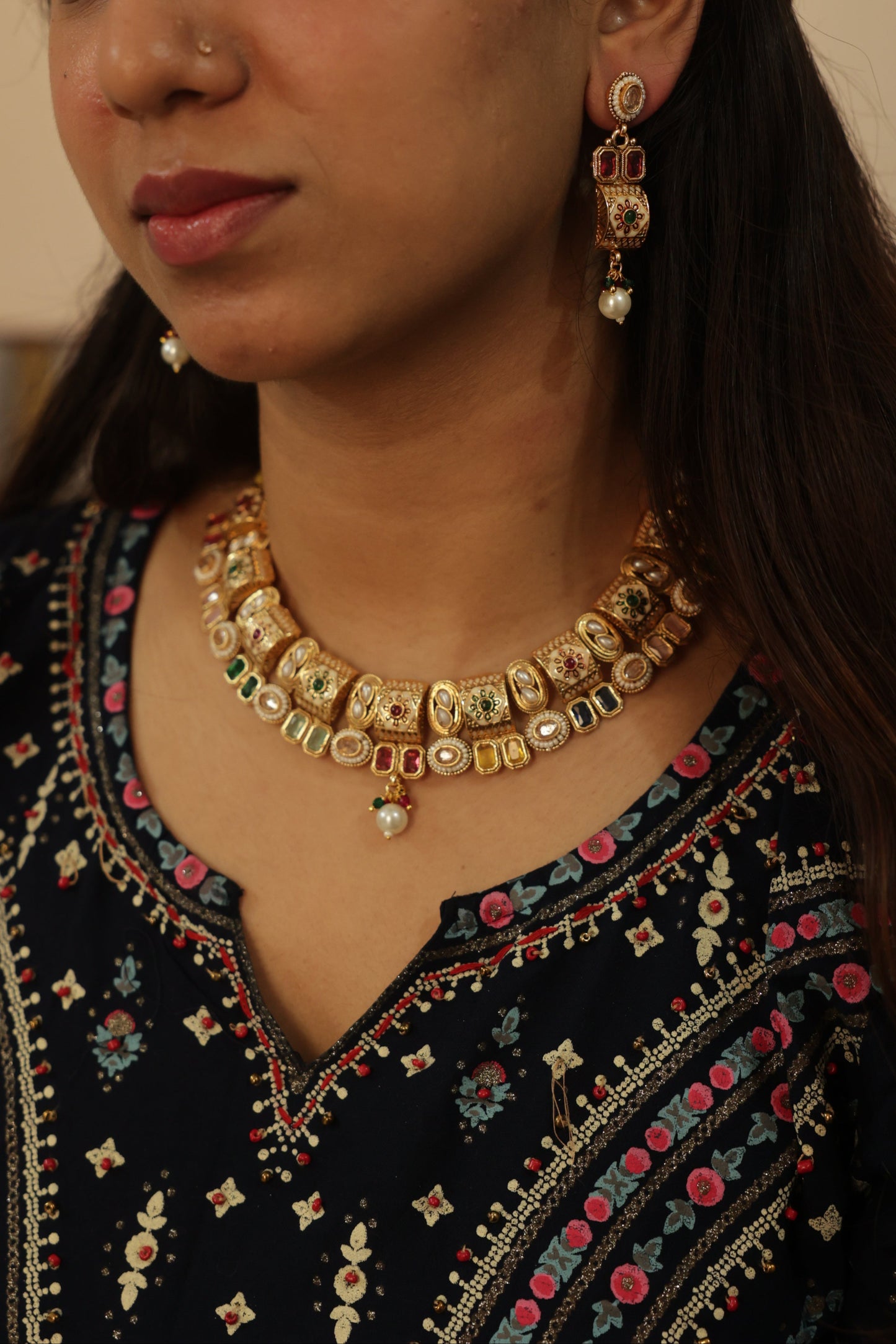 Woman wearing traditional jewelry with a focus on gold necklaces and earrings.