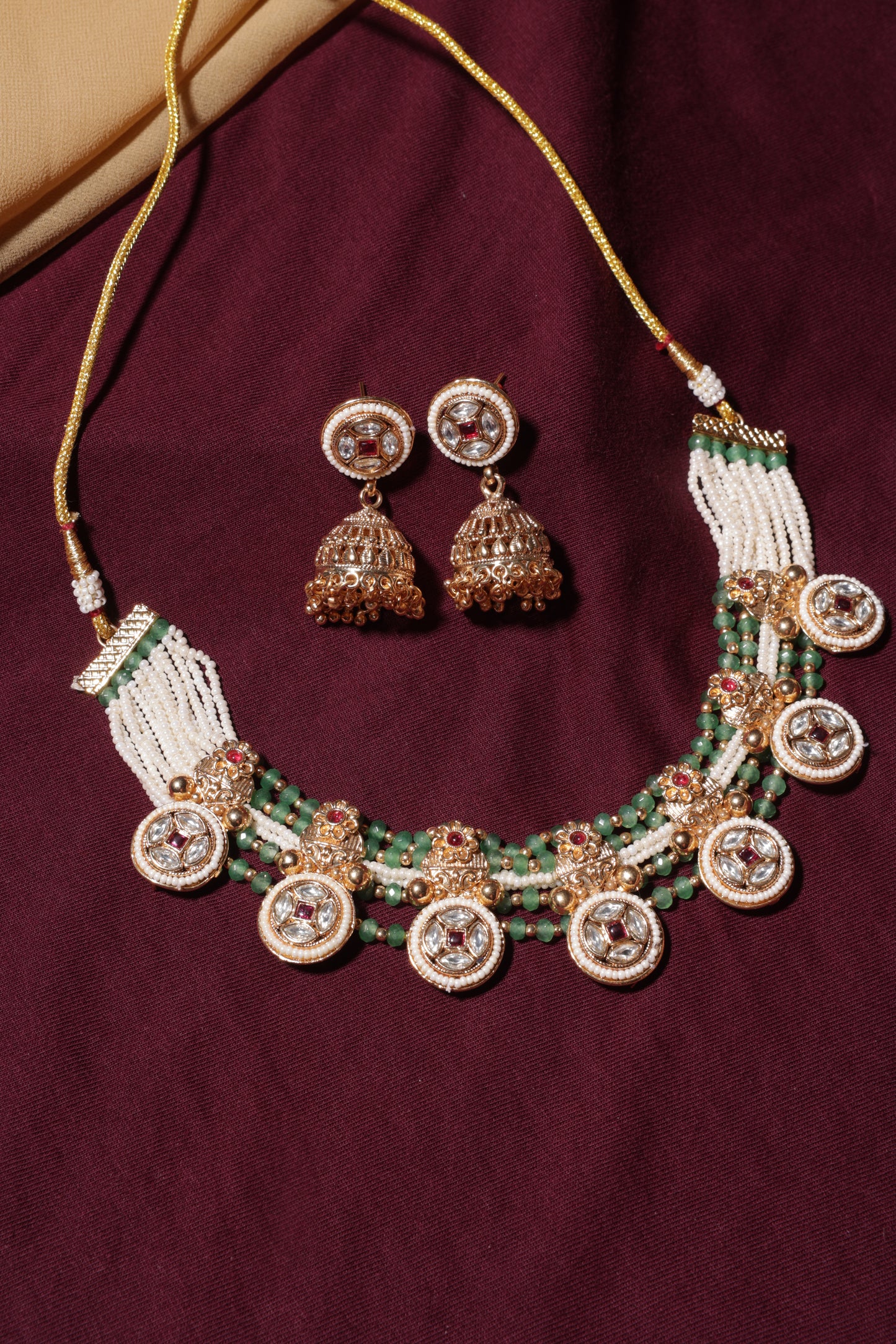 Jewelry set with necklace and earrings on a purple fabric background