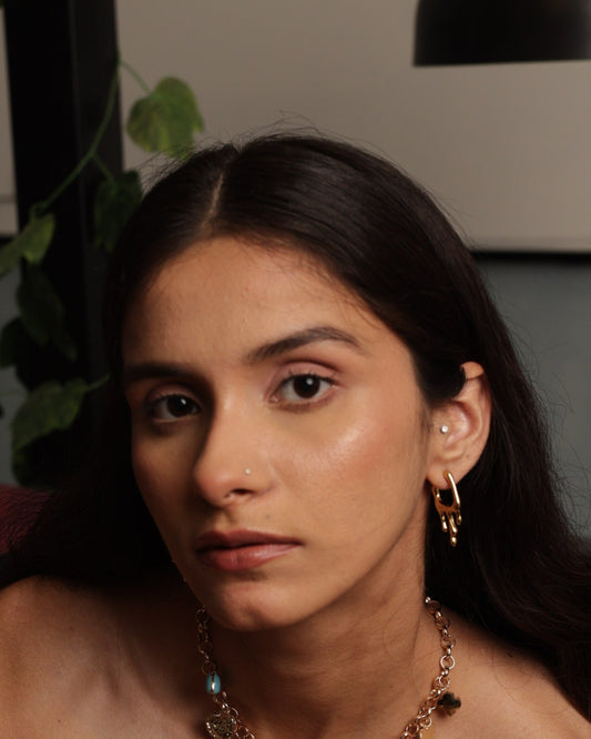 Woman wearing a necklace with heart pendants in an indoor setting