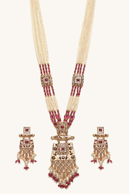 Ornate necklace with red gemstones and matching earrings on a white background