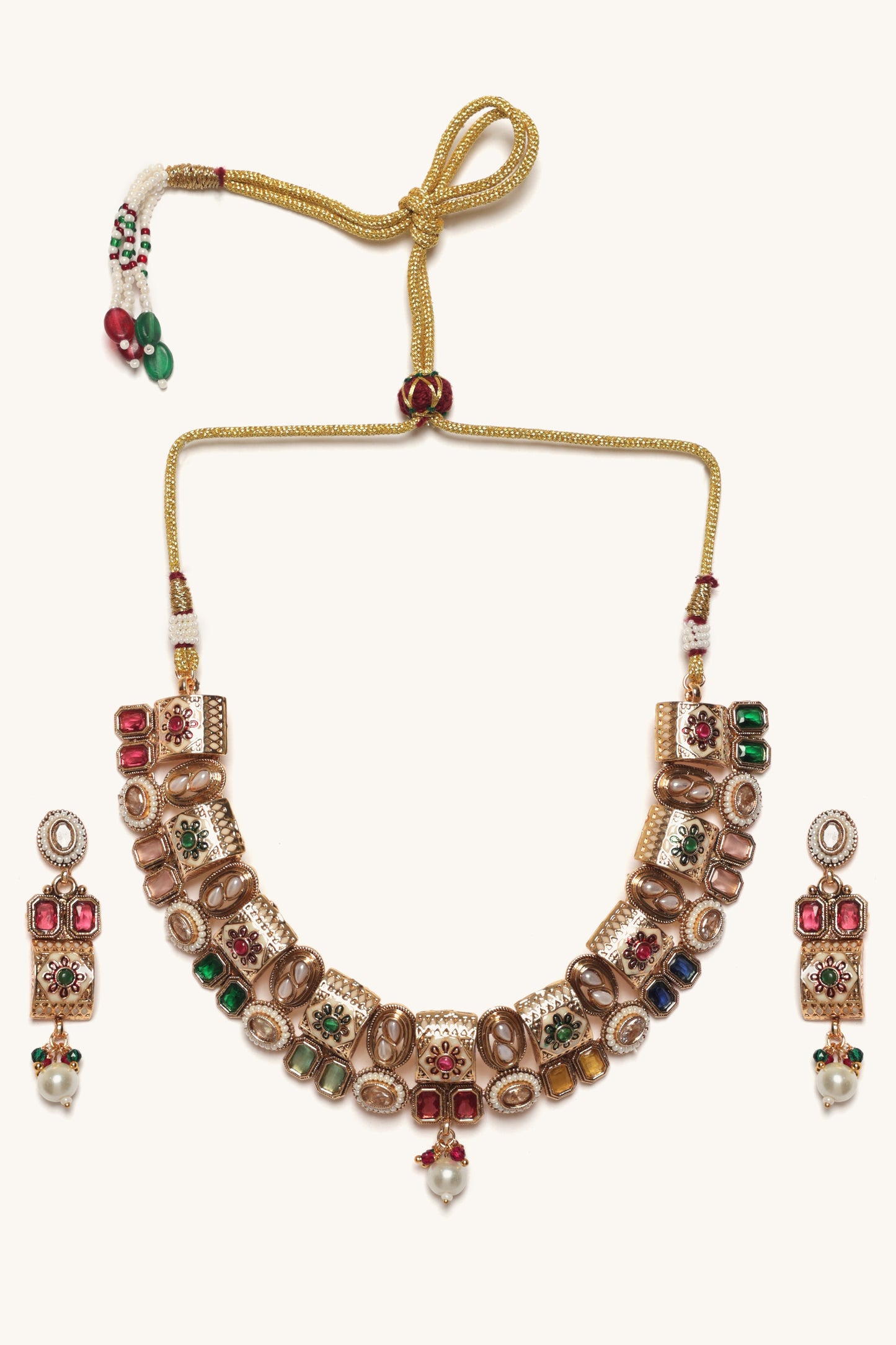 Ornate necklace set with red and green gemstones on a white background