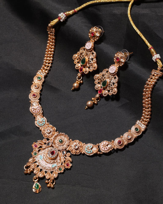 Ornate gold necklace with gemstones on a black background