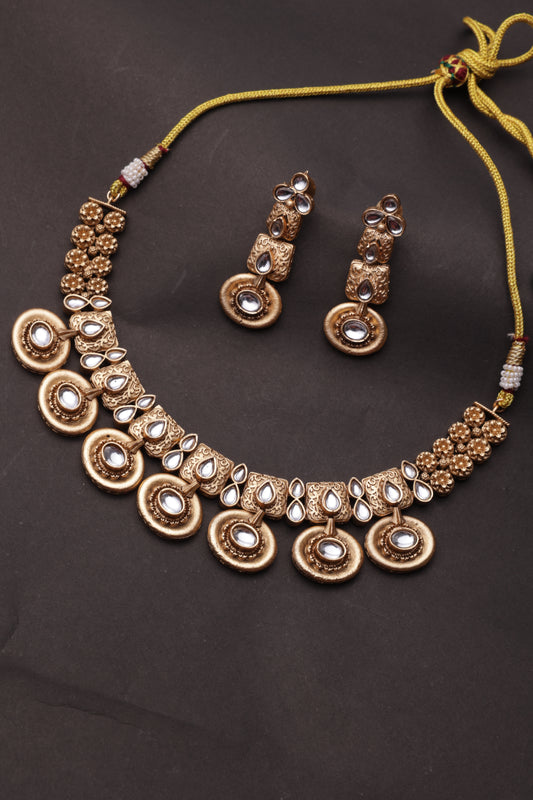 Gold necklace with embedded stones on a dark background