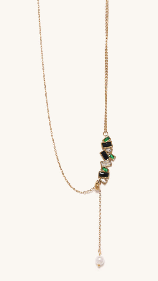 Gold necklace with green gemstones and a pearl on a white background